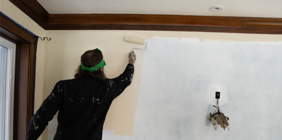 man rolling paint onto wall